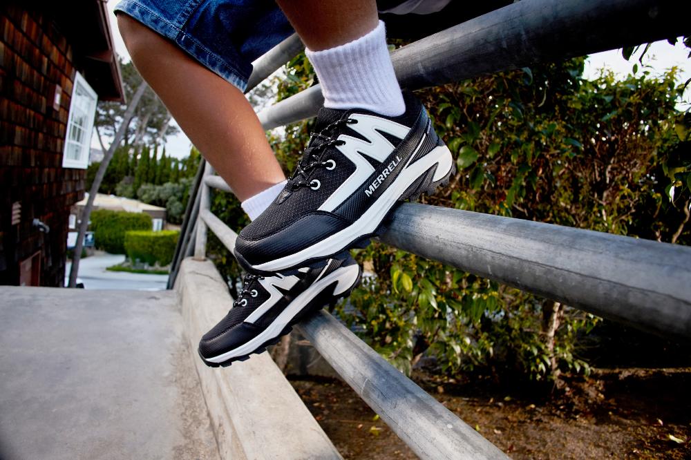 A child's feet shown wearing black trainers