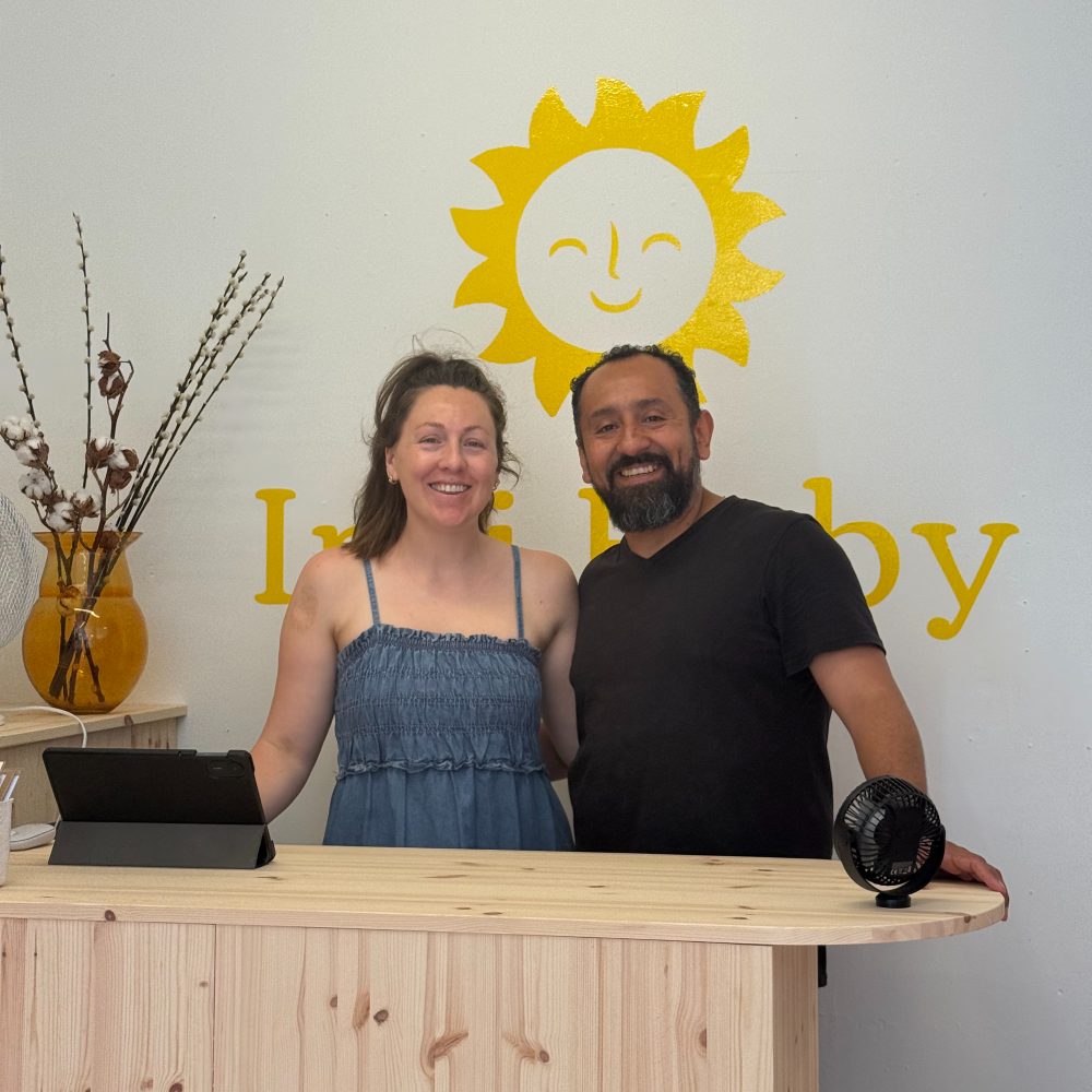 The owners of the baby and children's store Inti Baby stood behind the shop's counter 