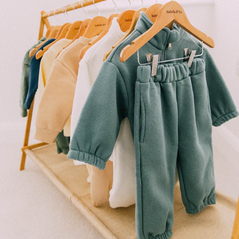 Baby clothes hung on a wooden rail 