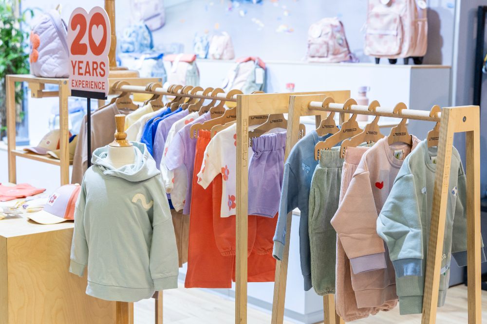 Children's clothes displayed on a stand at Kind + Jugend 