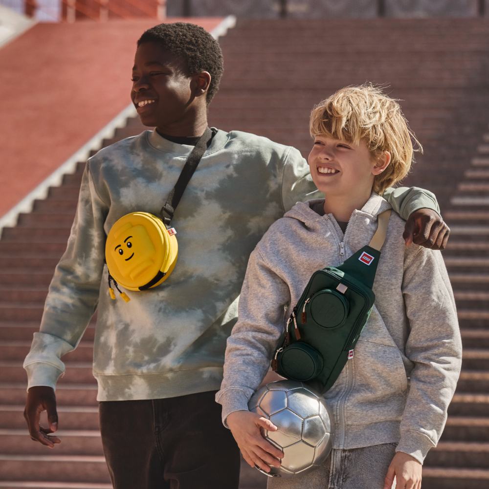Two boys outside carrying Lego bags 