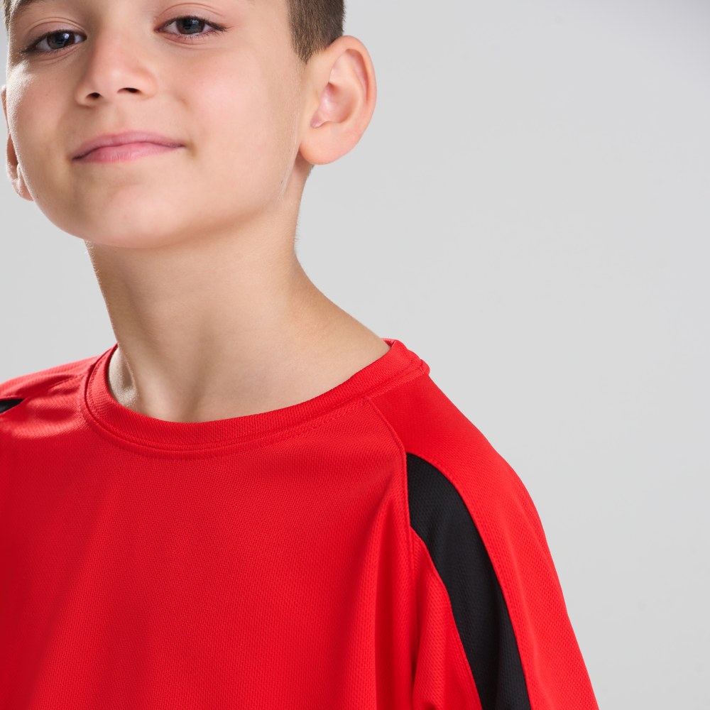 A young boy in a red T-shirt with a black stripe on the arm
