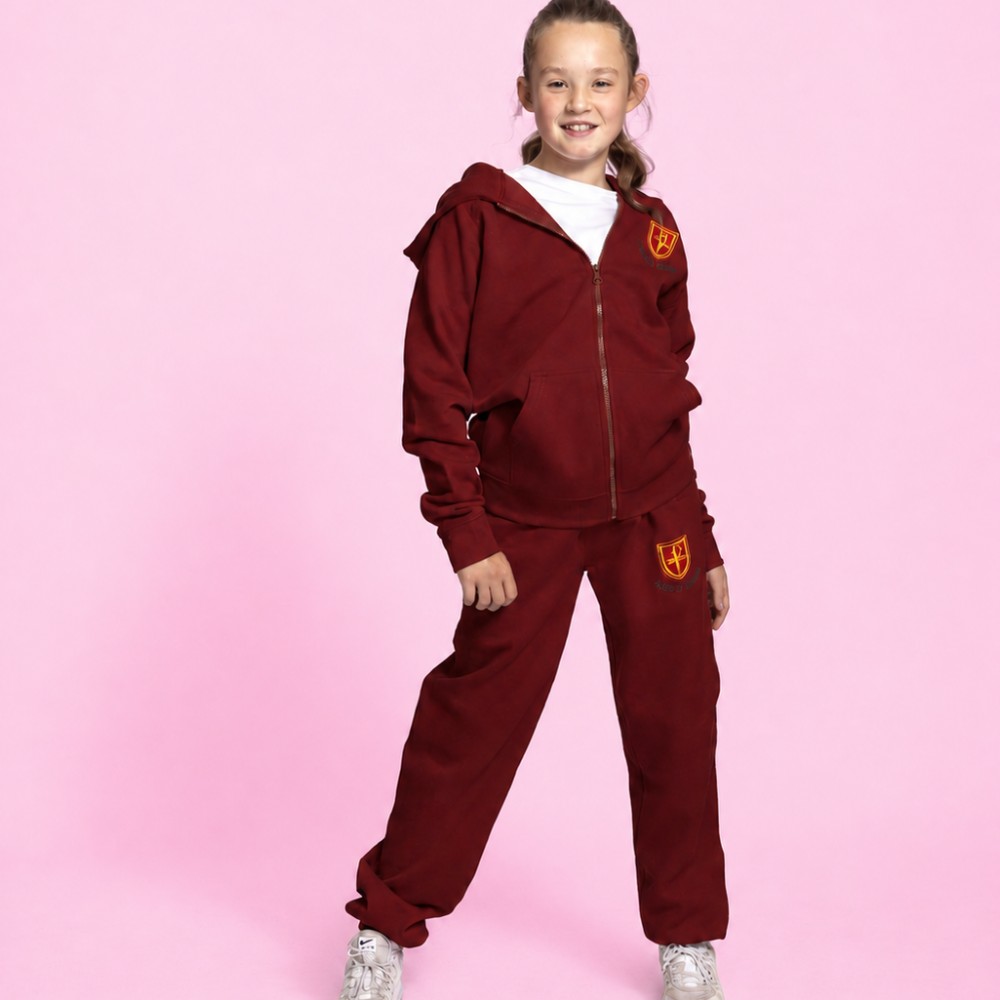A girl against a pink background wearing a maroon coloured tracksuit by One+All