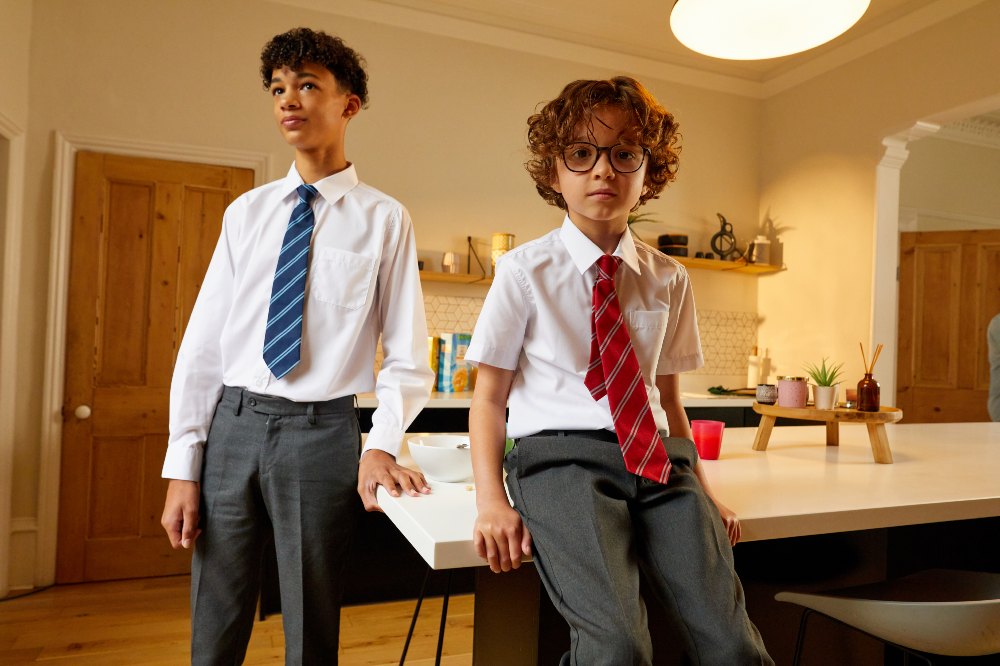 Two boys in a kitchen wearing David Luke school uniform