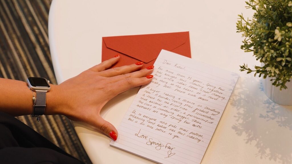 A hand shown beside a handwritten letter as part of Spring Fair's Love Letter to Retail campaign 