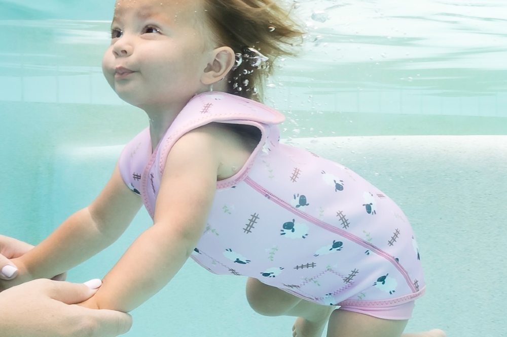 a baby shown swimming underwater wearing a costume by Splash About
