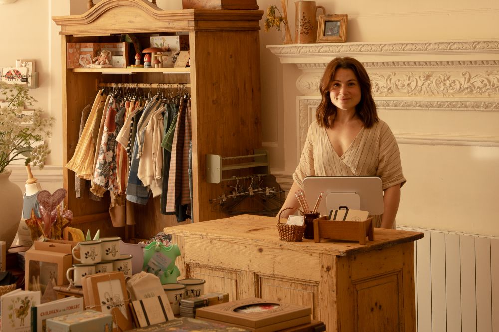 A woman stood behind the counter of The River Mouse children's store