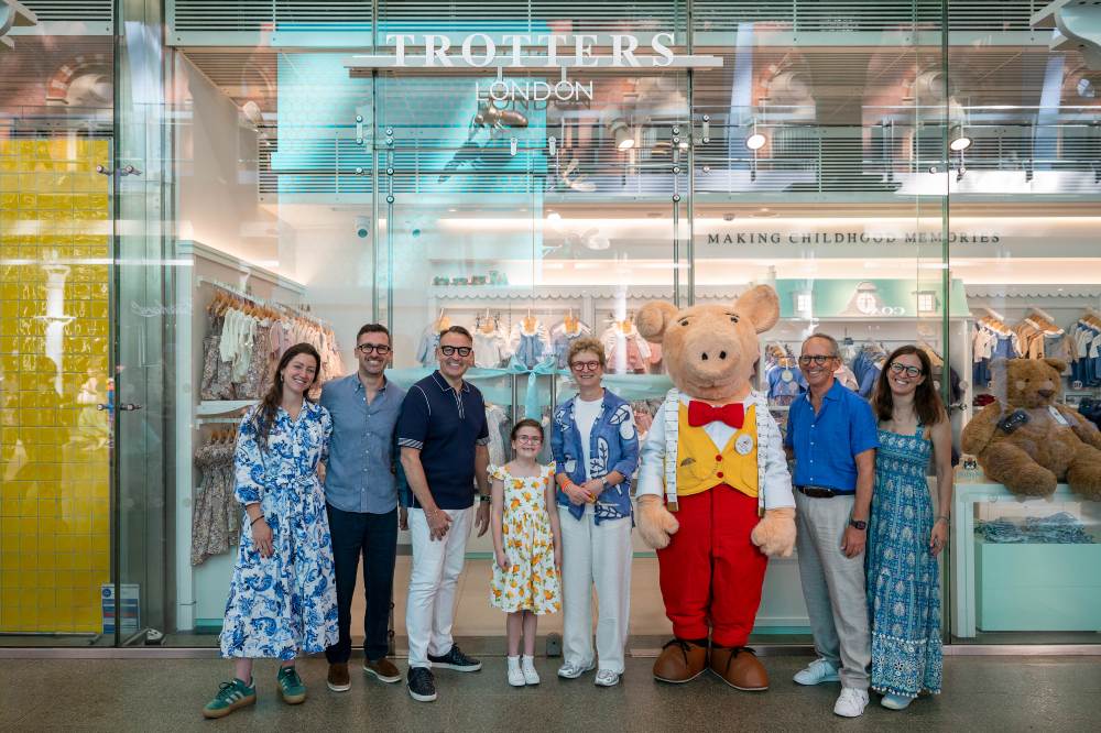 A group of people and a pig character stood outside the new St Pancras Trotters store
