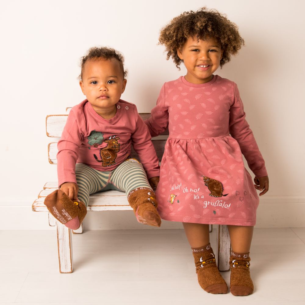 Two children sat on a bench wearing pink outfits from the new Blade & Rose The Gruffalo collection