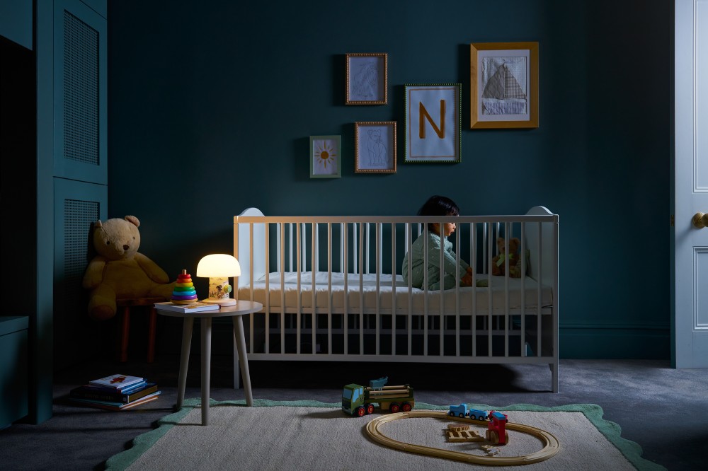 A child shown in a nursery with a Lumie Willow bedtime lamp on