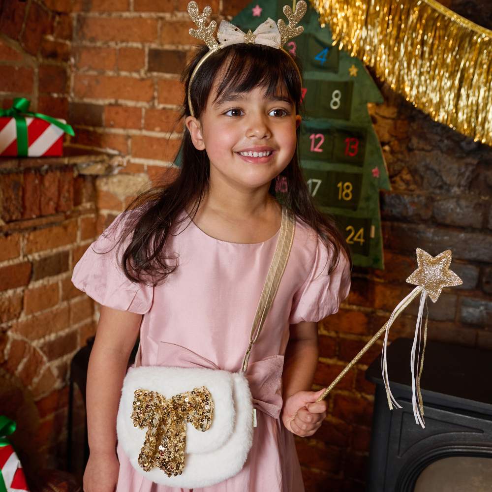 A girl in a pink dress with a bag and star wand from the Rockahula Kids Christmas collection
